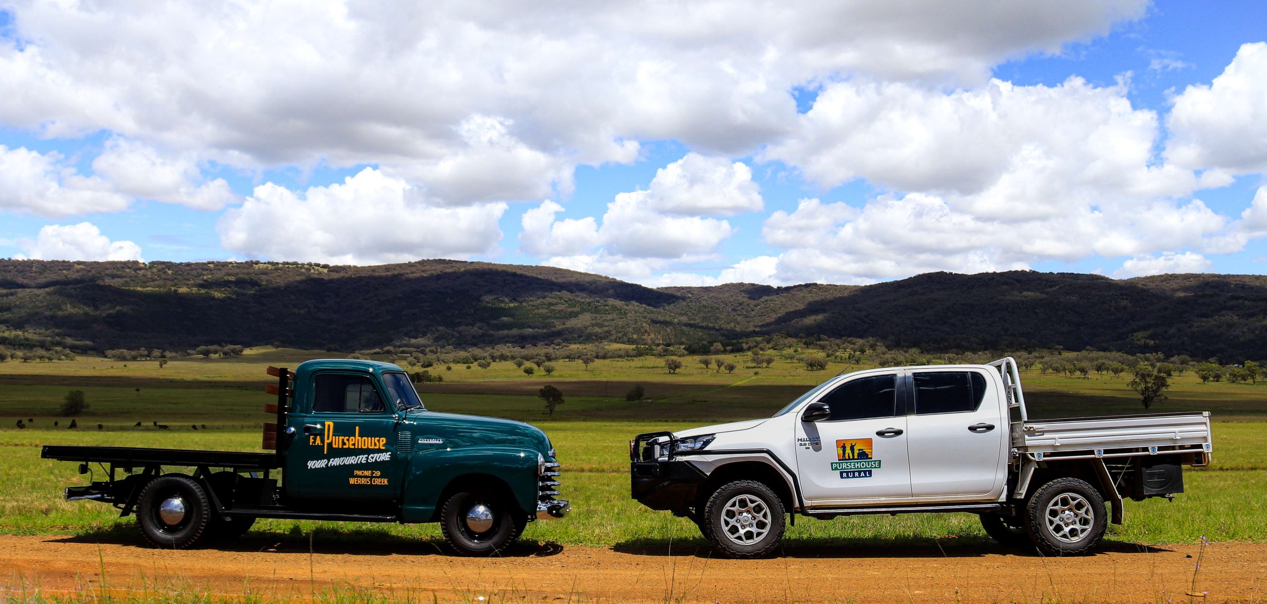 Old Pursehouse Rural Chevrolet truck faces new pursehouse rural Hilux ute in front of green paddock and hills